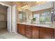 Bathroom with double sink vanity, wood cabinetry, and a large mirror at 20369 N 272Nd Ave, Buckeye, AZ 85396