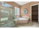 Relax in this luxurious bathroom featuring glass enclosed shower and separate soaking tub at 20369 N 272Nd Ave, Buckeye, AZ 85396