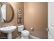 This powder room features a pedestal sink, designer mirror, and neutral tones at 20369 N 272Nd Ave, Buckeye, AZ 85396