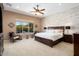 Bright primary bedroom with neutral tones, wood accent wall, ceiling fan, and large windows at 20369 N 272Nd Ave, Buckeye, AZ 85396