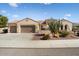 Inviting tan home with a three car garage, desert landscaping, and a charming patio area, perfect for outdoor living at 20369 N 272Nd Ave, Buckeye, AZ 85396