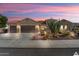 Inviting tan home with a three car garage, desert landscaping, and a charming patio area, perfect for outdoor living at 20369 N 272Nd Ave, Buckeye, AZ 85396