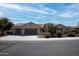Tan stucco house with two-car garage, Southwestern landscaping, and a brown tile roof at 20369 N 272Nd Ave, Buckeye, AZ 85396