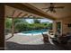Covered patio offers a peaceful outdoor space with comfortable seating and a view of the pool and greenery at 20369 N 272Nd Ave, Buckeye, AZ 85396