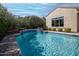 Backyard pool with surrounding greenery and an attached spa and waterfall at 20369 N 272Nd Ave, Buckeye, AZ 85396