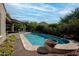 Beautiful backyard pool area with mature landscaping, a covered patio, and an inviting lounge space at 20369 N 272Nd Ave, Buckeye, AZ 85396