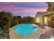 Backyard pool with desert landscaping, handrail, and outdoor patio at sunset at 20369 N 272Nd Ave, Buckeye, AZ 85396