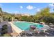 Backyard pool featuring decorative stone fire bowls, a stone surround, and mature desert landscaping at 20369 N 272Nd Ave, Buckeye, AZ 85396