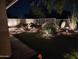 An attractive backyard includes a custom putting green, desert plants, night lighting, and privacy fence at 20435 N 39Th Dr, Glendale, AZ 85308