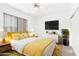 Stylish bedroom with a sunny yellow color scheme, bright lighting, and modern furnishings at 20435 N 39Th Dr, Glendale, AZ 85308