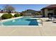 A community pool with light blue water, surrounded by green shrubbery and available lounge chairs for relaxing at 2059 E Brown Rd # 50, Mesa, AZ 85213