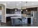 Modern kitchen with granite island, dark cabinetry, and stainless steel appliances at 22174 E Creekside Dr, Queen Creek, AZ 85142