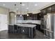 Modern kitchen with granite island, dark cabinetry, and stainless steel appliances at 22174 E Creekside Dr, Queen Creek, AZ 85142