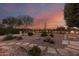 Backyard with fire pit, stone pathway, and desert plants at sunset at 23187 W Lasso Ln, Buckeye, AZ 85326