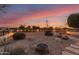 Backyard with fire pit, stone pathway, and desert plants at sunset at 23187 W Lasso Ln, Buckeye, AZ 85326