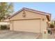 Two-car garage with tan stucco exterior and decorative accents at 23187 W Lasso Ln, Buckeye, AZ 85326