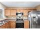Stainless steel appliances and wood cabinets in this kitchen at 23187 W Lasso Ln, Buckeye, AZ 85326