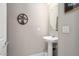 Convenient powder room with pedestal sink and oval mirror at 26467 W Zachary Dr, Buckeye, AZ 85396