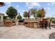 Outdoor kitchen with built-in grill and bar seating at 26702 W Sierra Pinta Dr, Buckeye, AZ 85396