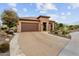 Single-story home with a brown garage door and nicely landscaped front yard at 26702 W Sierra Pinta Dr, Buckeye, AZ 85396