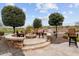 Stone fire pit with seating, overlooking a golf course at 26702 W Sierra Pinta Dr, Buckeye, AZ 85396