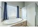 Relaxing bathroom with soaking tub, walk-in shower, and large window at 3121 E Hackamore St, Mesa, AZ 85213