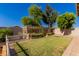 Backyard featuring a greenhouse, garden beds, a white fence, and lush greenery at 6512 W Eagle Talon Trl, Phoenix, AZ 85083