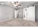 Spacious bedroom with ceiling fan and barn door to the bathroom at 6512 W Eagle Talon Trl, Phoenix, AZ 85083