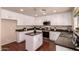 Bright kitchen showcases white cabinetry, granite counters, stainless appliances, hardwood floors, and a functional center island at 6512 W Eagle Talon Trl, Phoenix, AZ 85083