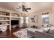 Inviting living room with built-in shelving, modern furnishings, and large windows, creating a comfortable and stylish ambiance at 6512 W Eagle Talon Trl, Phoenix, AZ 85083
