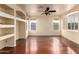 Living room with hardwood floors, built-in shelving, and large windows at 6512 W Eagle Talon Trl, Phoenix, AZ 85083