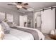 Inviting primary bedroom has a modern barn door to the en suite bath, soft decor, and a ceiling fan at 6512 W Eagle Talon Trl, Phoenix, AZ 85083