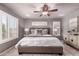 This primary bedroom is well lit and features modern decor, a ceiling fan, and plantation shutters at 6512 W Eagle Talon Trl, Phoenix, AZ 85083