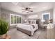 Relaxing main bedroom boasts neutral tones, a ceiling fan, plantation shutters, and a patterned rug at 6512 W Eagle Talon Trl, Phoenix, AZ 85083