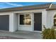 Front door entry with black security door and a gray garage door to the side at 10001 N 87Th Ln, Peoria, AZ 85345