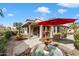 Landscaped backyard featuring a fountain and covered patio at 10605 E Nacoma Dr, Sun Lakes, AZ 85248