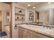 Double vanity bathroom with tile details, built in shelving and a large mirror at 26325 N 107Th Way, Scottsdale, AZ 85255