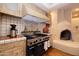 Rustic kitchen with a wood-burning stove and tile backsplash at 26325 N 107Th Way, Scottsdale, AZ 85255