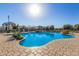 Bright and sunny community pool surrounded by chairs, lush greenery, and well maintained landscaping at 1094 S 151St S Ln, Goodyear, AZ 85338