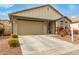 Beige house with a two-car garage and well-maintained landscaping at 1094 S 151St S Ln, Goodyear, AZ 85338