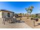 Outdoor patio featuring a dining table, chairs, desert landscaping and a built in barbecue grill at 1094 S 151St S Ln, Goodyear, AZ 85338