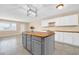 Kitchen with gray island, white cabinets, and wood countertops at 12451 N Cherry Hills E Dr, Sun City, AZ 85351