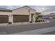 Tan two-car garage home with brown doors and landscaping at 1255 N Arizona Ave # 1109, Chandler, AZ 85225