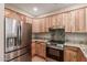 Modern kitchen featuring stainless steel appliances and wood cabinets at 14250 W Wigwam Blvd # 2121, Litchfield Park, AZ 85340