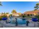 Kidney-shaped pool with mermaid statues and blue planters at 14316 W Circle Ridge Dr, Sun City West, AZ 85375