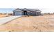 Single-story house with gray exterior, solar panels, and a long driveway at 1529 S 357Th Ave, Tonopah, AZ 85354