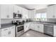 Modern kitchen with white cabinets, gray countertops, and stainless steel appliances at 1529 S 357Th Ave, Tonopah, AZ 85354