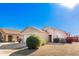 Tan house with a two-car garage and desert landscaping at 15365 W Caribbean Ln, Surprise, AZ 85379