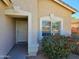 House entrance with a tan door and red flowers at 15365 W Caribbean Ln, Surprise, AZ 85379