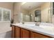 Bathroom with double sink vanity, tiled floor, tub, and large mirror reflecting natural light at 163 W Dragon Tree Ave, Queen Creek, AZ 85140